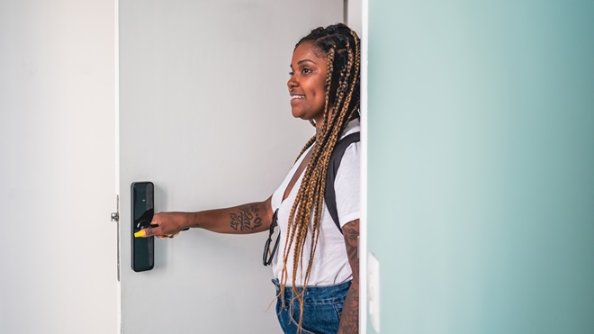 woman using a smart lock to open a door